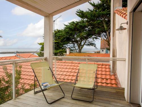 two chairs on a balcony with a view of a roof at Holiday Home Ker Mylio by Interhome in La Bernerie-en-Retz