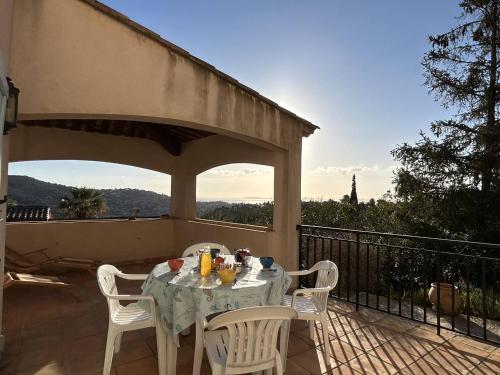 une table et des chaises sur un balcon avec vue dans l'établissement Maison calme 4 pièces, 3 chambres, vue mer, Bormes-les-Mimosas - FR-1-251-849, à Bormes-les-Mimosas