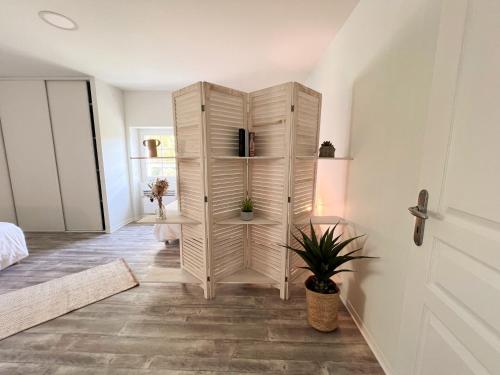 une armoire blanche dans une pièce avec une plante dans l'établissement La Grange Animation, à Pomarez