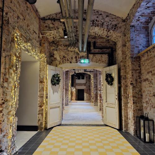 a hallway in an old building with christmas lights at ARCHE Klasztor Wrocław in Wrocław