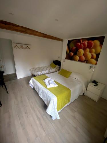 a bedroom with a bed with a painting of fruit on the wall at Hôtel Le Chambellan in Dijon