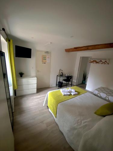 a bedroom with a large bed with a yellow blanket at Hôtel Le Chambellan in Dijon