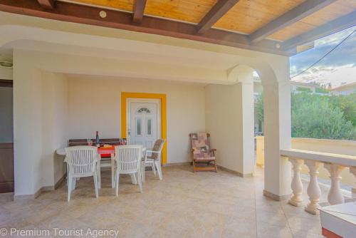a patio with a table and chairs and a ceiling at Stanko in Kustići