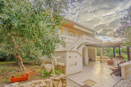 an exterior view of a house with trees and a patio at Stanko in Kustići