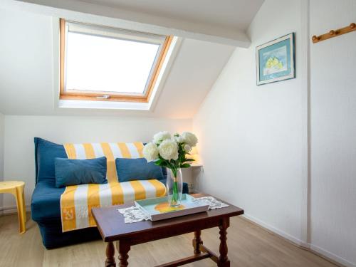 Una sala de estar con un sofá azul y una mesa. en Apartment Les Tilleuls-1 by Interhome, en La Bernerie-en-Retz