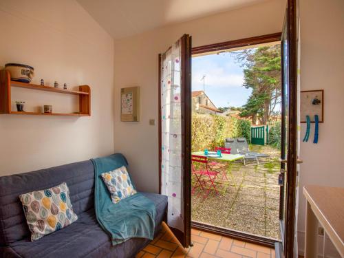 a living room with a couch and a sliding glass door at Holiday Home Plein Océan-4 by Interhome in Pornic