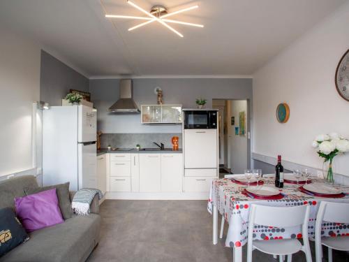 une cuisine et un salon avec une table et un canapé dans l'établissement Apartment Les Tilleuls-2 by Interhome, à La Bernerie-en-Retz