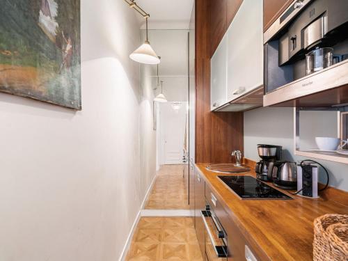 ディナールにあるApartment Le Caroline by Interhomeの白い壁と木製のカウンタートップが備わるキッチン