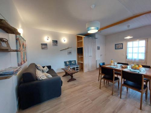 ein Wohnzimmer mit Sofa und Tisch in der Unterkunft Holiday Home Charme de la Petite Bosse by Interhome in LʼÉpine