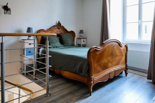 une chambre avec un lit avec une tête de lit en bois dans l'établissement Appartement situé au cœur des belles ruelles sablaises - 5 pers, à Les Sables-dʼOlonne