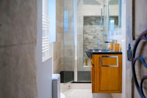une salle de bain avec un lavabo et une douche en verre dans l'établissement Appartement situé au cœur des belles ruelles sablaises - 5 pers, à Les Sables-dʼOlonne