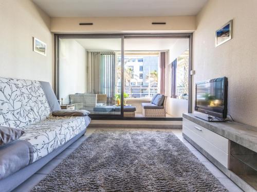un salon avec un canapé et une télévision dans l'établissement Apartment Le Sunset-Cap Sud-26 by Interhome, au Cap d'Agde