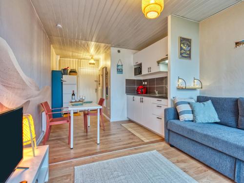 un salon avec un canapé bleu et une table dans l'établissement Studio Les Sables d'Argent-10 by Interhome, à Lacanau-Océan