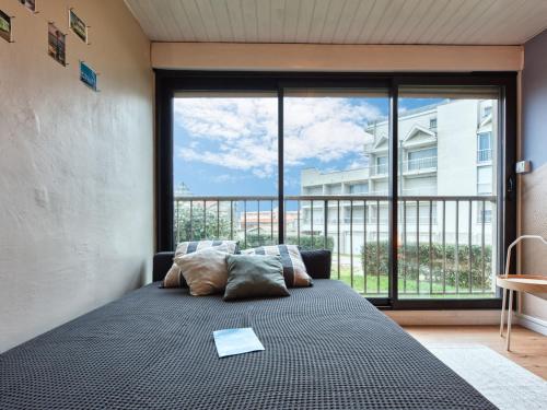 une chambre avec un lit avec une grande fenêtre dans l'établissement Studio Les Sables d'Argent-10 by Interhome, à Lacanau-Océan