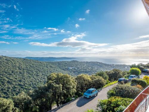 une voiture bleue garée sur une route arborée dans l'établissement Apartment Les Sauvagières II-7 by Interhome, à Cavalaire-sur-Mer
