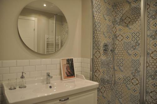 a bathroom with a sink and a shower with a mirror at Nova Acacie Mi3 - Entire Apartment in Basiglio