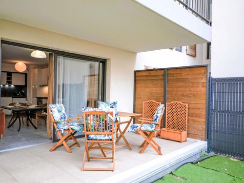 d'un patio avec des chaises à bascule et une table. dans l'établissement Apartment Pigonnet by Interhome, à Aix-en-Provence