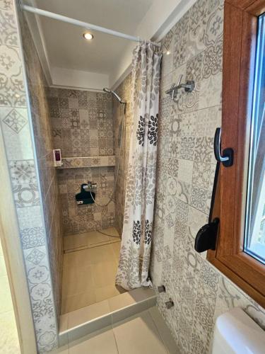 a shower with a shower curtain in a bathroom at Lilian Luxury Villa Halkidiki in Nea Fokea