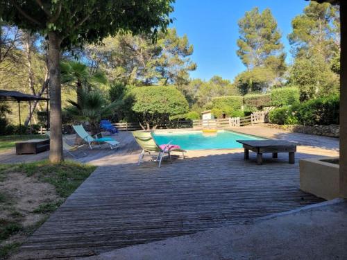 - une piscine avec des chaises, une table et un banc dans l'établissement Holiday Home Villa au coeur de la Foret by Interhome, à Puget-Ville