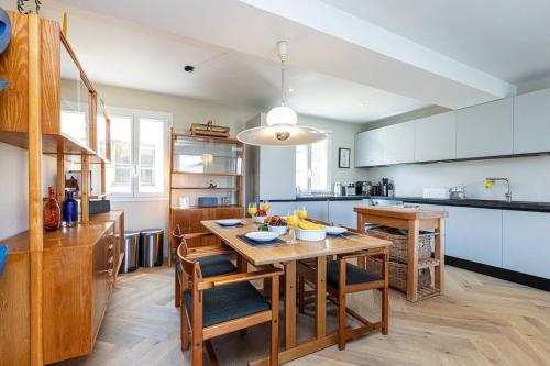 une cuisine avec une table en bois et des chaises ainsi qu'une salle à manger dans l'établissement 2 chambres, balcons, vue imprenable, climatisation - PALACE BLEU, à Nice