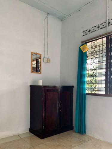 a room with a wooden cabinet and a window at Beach Guest House in Maninjau