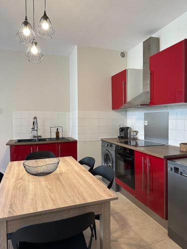 une cuisine avec une table en bois et des placards rouges dans l'établissement Casa del Sol, À quelques pas du port et des plages, à Bandol
