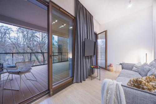 ウッチにあるPark Zen, taras i widok na parkのソファとバルコニーのあるリビングルーム