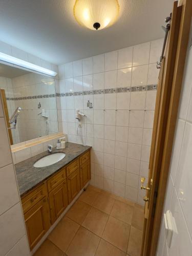 a bathroom with a sink and a mirror at Ferienwohnungen am Kurpark in Roßhaupten