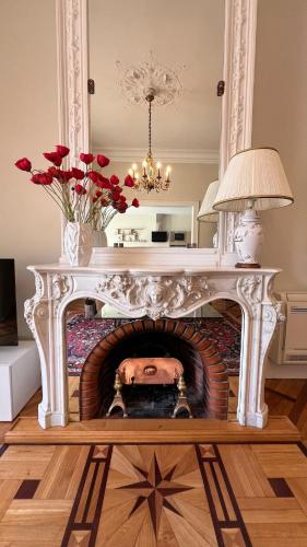 un salon avec une cheminée avec une table et des fleurs dans l'établissement Le vintage, à Bouzigues