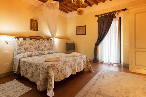 a bedroom with a bed and a large window at Fattoria Poggio Capponi in Montespertoli