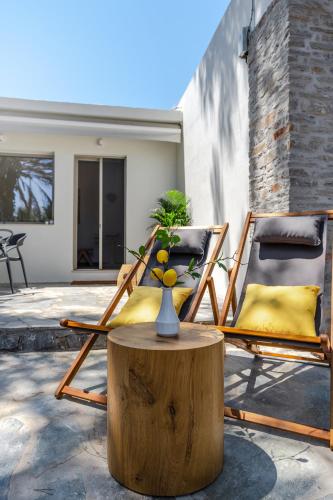 two chairs and a table with a vase on a stump at Lemoni House in Petras, Sitia, by Comfortbnb in Sitia
