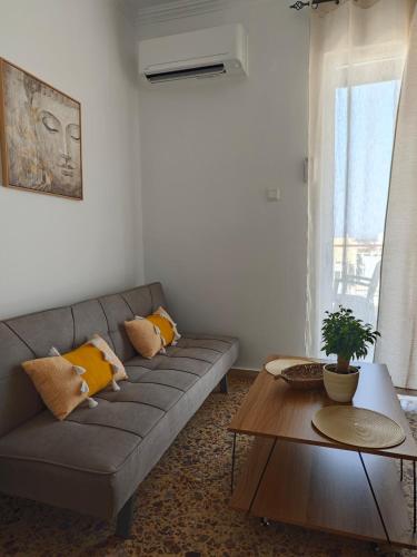 a living room with a couch and a table at Aspa and Alex penthouse retreat in Koropíon