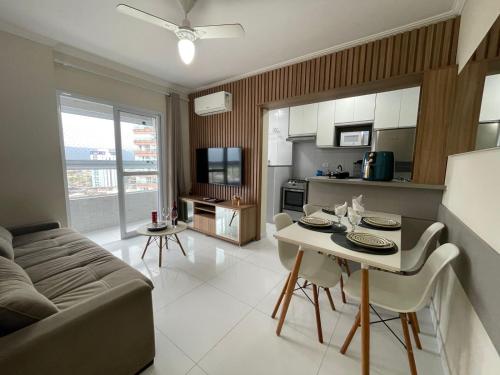 a kitchen and living room with a couch and a table at Apartamento com Varanda Gourmet e Wi-Fi Rápido - Renove as Energinas Vila Caiçara Praia Grande in Praia Grande