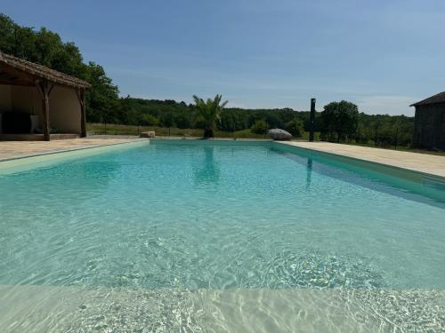 a large swimming pool with blue water at Le Clos des 4 Bastides in Saint-Eutrope-de-Born