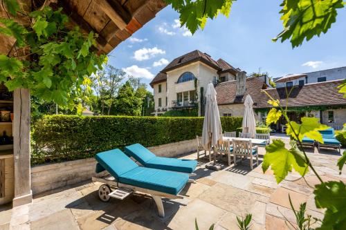 a patio with chairs and umbrellas and a house at LeSable luxury vacation home in Kluisbergen