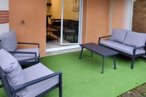 d'une terrasse avec deux chaises et une table. dans l'établissement Beau soleil - Résidence avec Parking et piscine - Proche airport, à Blagnac
