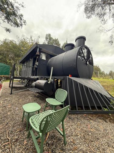 a train engine with two chairs and two tables at Rancho Las Santas in Guasca