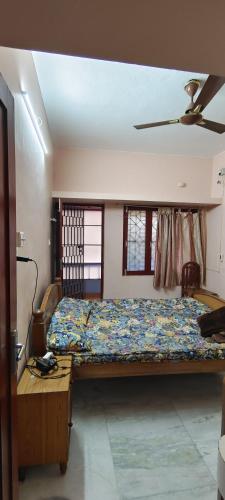 ein Schlafzimmer mit einem Bett und einem Tisch und Fenstern in der Unterkunft White Town Home Stay in Puducherry