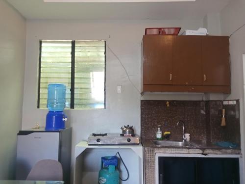 a small kitchen with a stove and a sink at Baverlly Home Stay in Cotabato