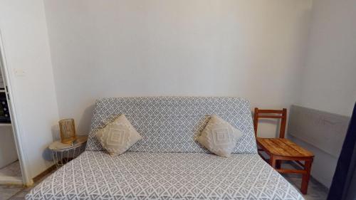 - un canapé avec deux oreillers dans l'établissement La Pause Oceane, à Bretignolles-sur-Mer