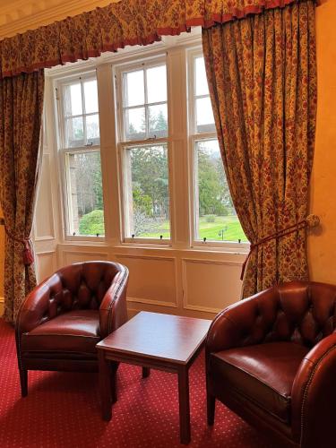 two chairs and a table in front of a window at Ramnee Hotel in Forres