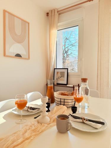 a dining room table with two plates and wine glasses at Cozy apartment near Paris in Clamart