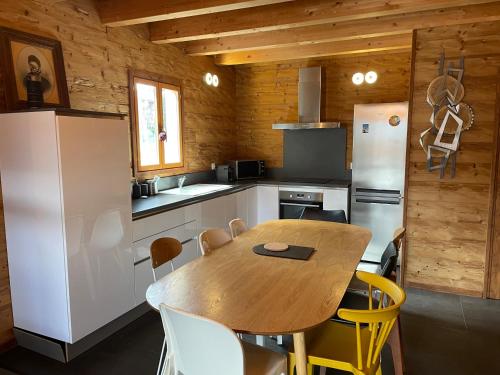 une cuisine avec une table en bois et un réfrigérateur dans l'établissement Chalet mitoyen à Bolquère pour 8 personnes, à Bolquère-Pyrénées 2000