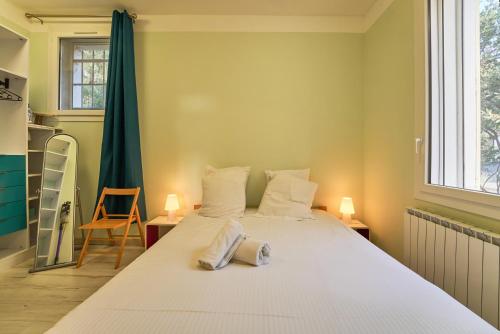 a bedroom with a large white bed with two lamps at Havre familial cosy avec terrasse & lumière in Toulon
