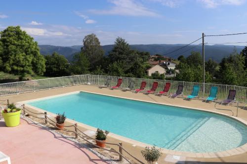 une grande piscine avec des chaises et une clôture dans l'établissement Chalet Jordan - Mas Lachamp, à Gravières