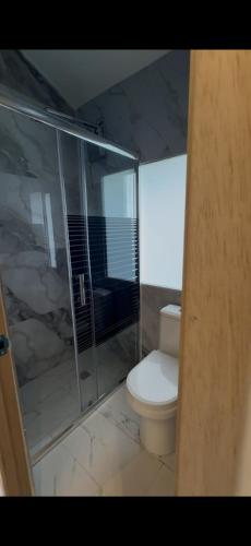a bathroom with a toilet and a glass shower at Rancho Las Santas in Guasca