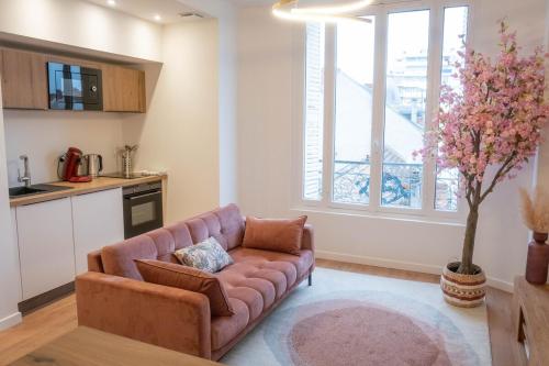 un salon avec un canapé et une cuisine dans l'établissement La rose des vents, à Vichy