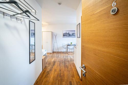 a hallway with a wooden door and a table at Mitte Apartments in Brno