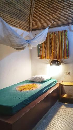 a bed in a room with a window at LE BENTENIER Home Détente in Nianing