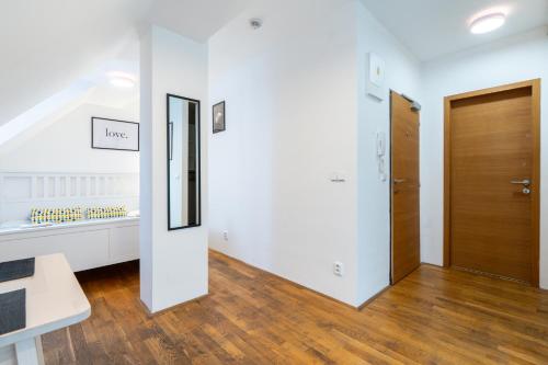 a hallway with white walls and a wooden door at Mitte Apartments in Brno